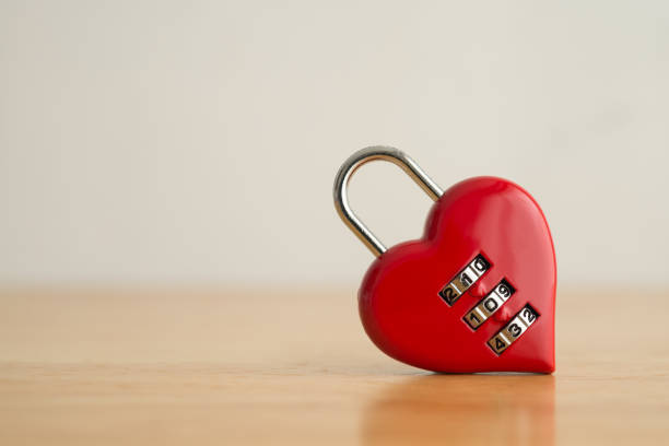 istock Love red heart shape code lock on wooden white wall background. 1605325976