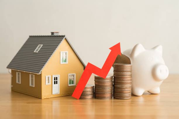 gráfico gráfico vermelho subindo em modelo de casa de moedas de pilha e cofrinho em mesa de madeira. - pension finance retirement graph - fotografias e filmes do acervo