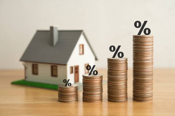 istock Stack coins as graph trend up and interest rates with house model background. 1605330541