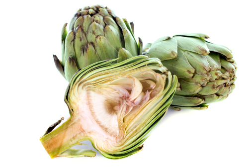 three artichokes in front of white background