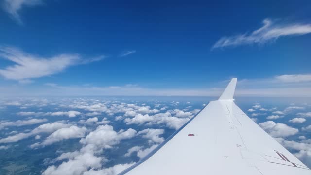Business jet aircraft window view. Beautiful clouds in the sky. 4K UHD video footage