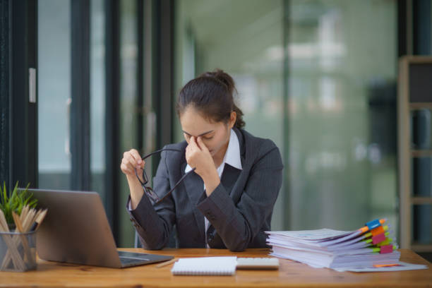istock Tired businesswoman working on a computer in a modern office, headache. 1605344152