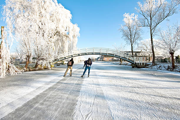 Ice skating on a frozen canal in the countryside in winter in the Netherlands