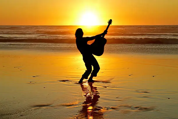 Guitarplayer at sunset on the beach