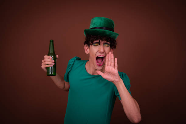 istock Drag Queen on St. Patrick's Day in a green hat drinks green beer. 1605348465