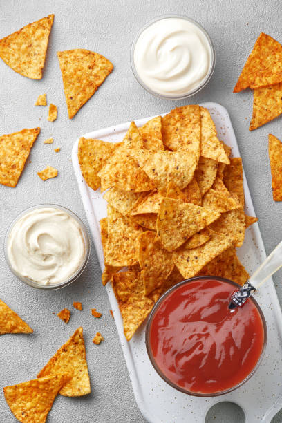 istock Tortilla chips and various dips on a gray background viewed from above. Mexican fast food. Top view 1605350671