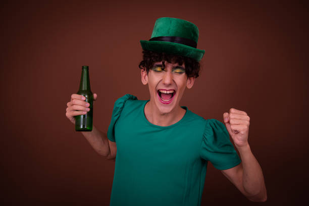 istock Drag Queen on St. Patrick's Day in a green hat drinks green beer. 1605351733
