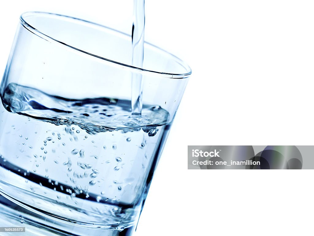 glass with pouring water Transparent glass with pouring water into it Blue Stock Photo