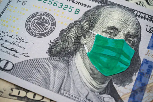 Benjamin Franklin president wear face mask on US dollar bill banknote background. Global novel coronavirus (Covid-19) outbreak effect to USA, world economy, financial crisis, investment, stock market.