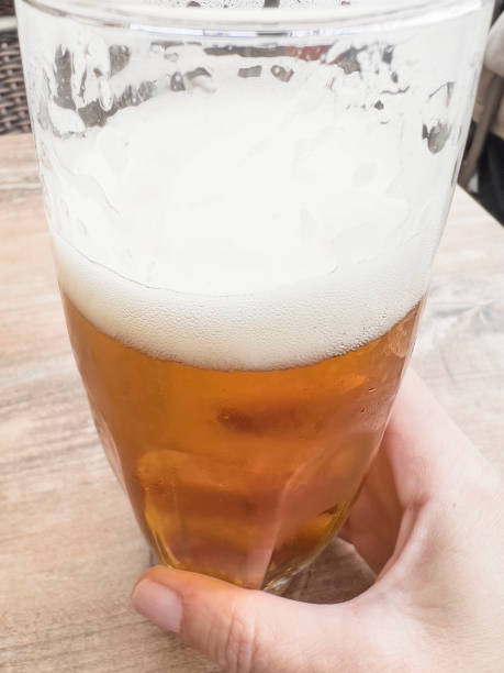 istock hand holding glass of beer 1605367783