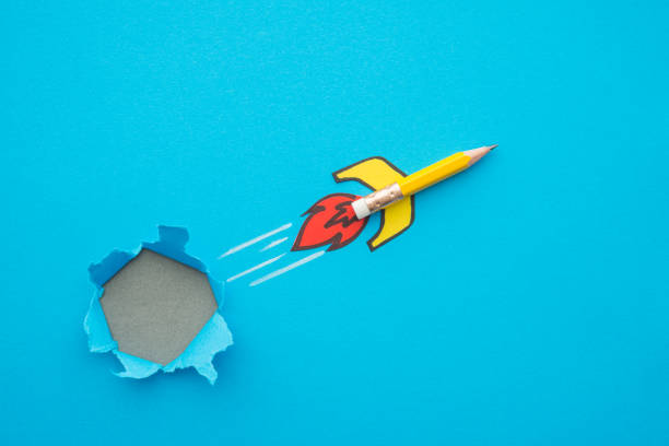 Yellow pencil rocket breaking through hole from obstacle wall to blue zone background.