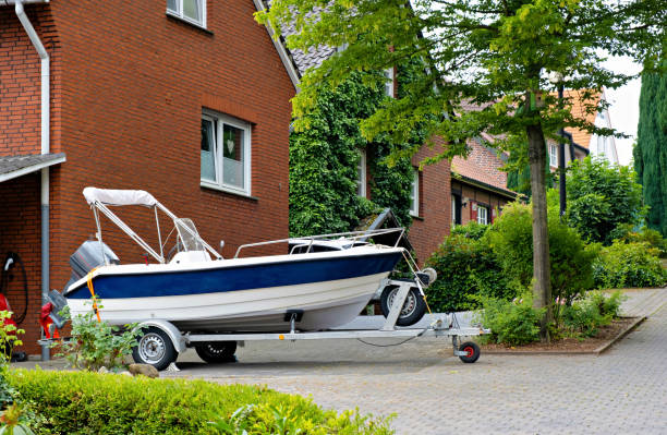 Blue and white boat parked in front of red brick building with white roof. stock photo