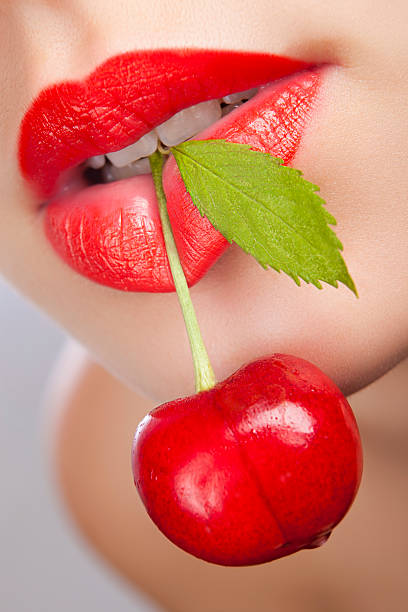 istock girl holding a cherry in teeth 160537802
