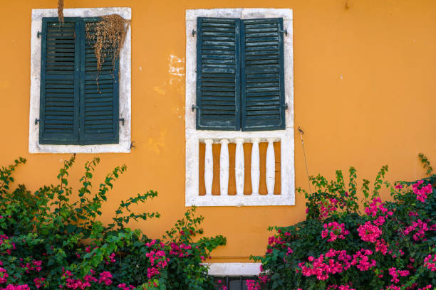 istock Green window shutters on an orange building in Greece 1605378504