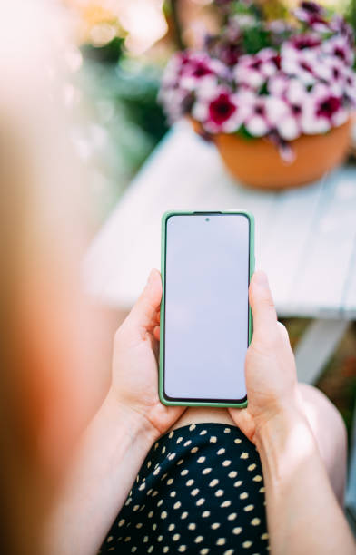 istock Woman Holding Smartphone in Her Hand 1605379062