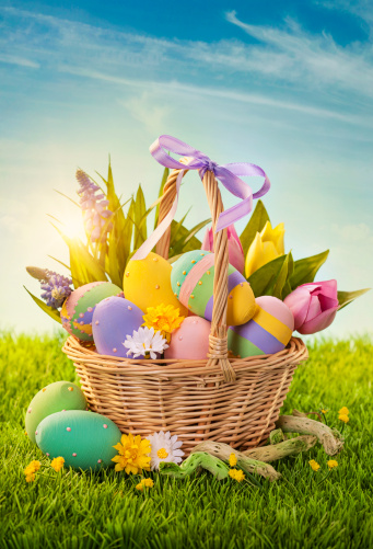 Basket with easter eggs  on green grass