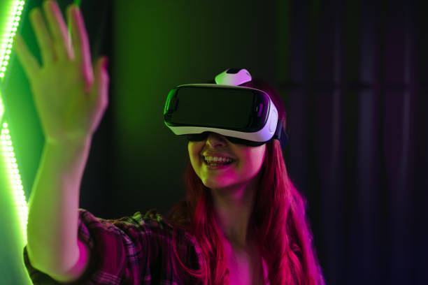 istock Happy young woman interacting with a VR game using a virtual reality headset 1605396001