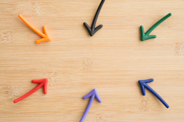 istock Color highlight arrows put around on wooden background. 1605396370