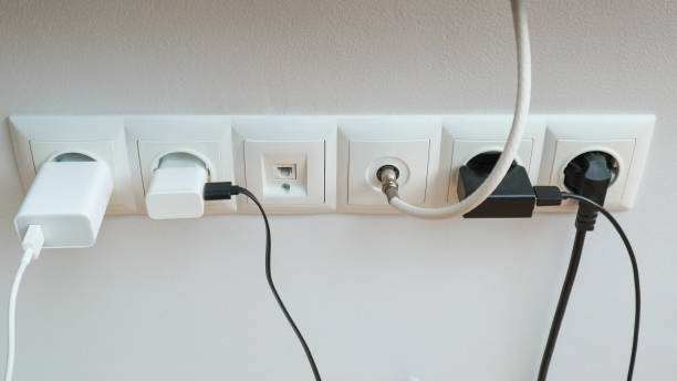 istock Many chargers plugged into maltiple electrical outlet on white background. Concept of electricity consumption. 1605396659
