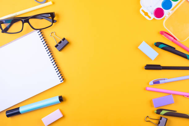 istock School notebook and various stationery on yellow background. 1605401383