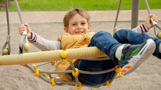 tire swing on metal chains in a public park (mount prospect park brooklyn new york city) urban playground, rubber mat flooring for kids, benches,   infrastructure, recreation rope