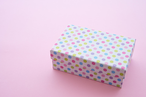Top view of colorful pastel dot gift box on pink background and copy space. Credit card reward point, cash back, bonus for special member concept. Business and financial shopping sale promotion.