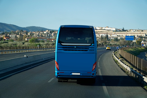 Blue tourist bus on a highway in Spain - back view