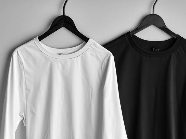 istock Realistic tshirt mockup | Blank black and white t-shirt on hanger, design mockup. Clear plain cotton tshirt mock up template. Apparel store logo mock branding display 1605406912