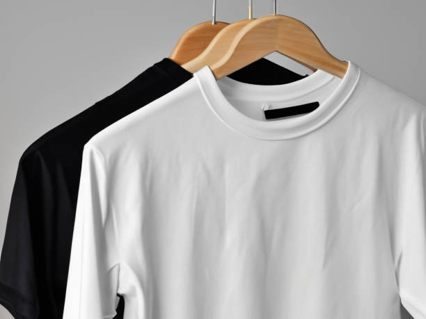istock Realistic tshirt mockup | Blank black and white t-shirt on hanger, design mockup. Clear plain cotton tshirt mock up template. Apparel store logo mock branding display 1605409669