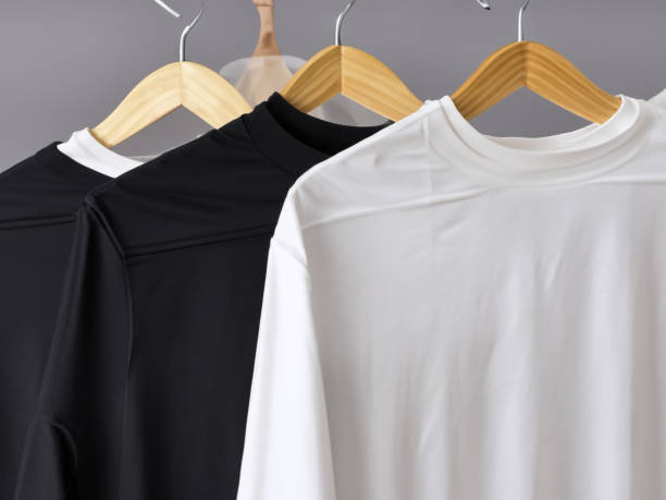 istock Realistic tshirt mockup | Blank black and white t-shirt on hanger, design mockup. Clear plain cotton tshirt mock up template. Apparel store logo mock branding display 1605409688