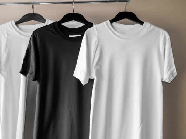 istock Realistic tshirt mockup | Blank black and white t-shirt on hanger, design mockup. Clear plain cotton tshirt mock up template. Apparel store logo mock branding display 1605413118