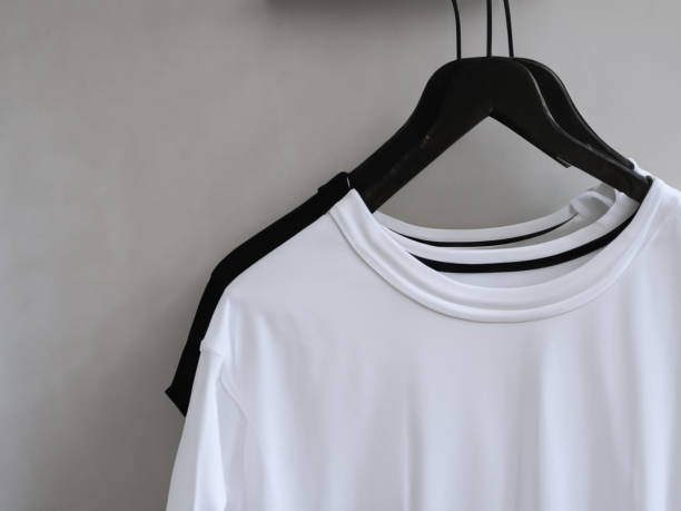 istock Realistic tshirt mockup | Blank black and white t-shirt on hanger, design mockup. Clear plain cotton tshirt mock up template. Apparel store logo mock branding display 1605413690