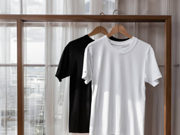 istock Realistic tshirt mockup | Blank black and white t-shirt on hanger, design mockup. Clear plain cotton tshirt mock up template. Apparel store logo mock branding display 1605414444