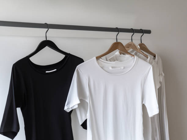 istock Realistic tshirt mockup | Blank black and white t-shirt on hanger, design mockup. Clear plain cotton tshirt mock up template. Apparel store logo mock branding display 1605414752