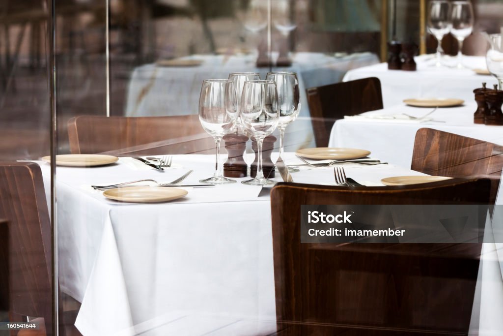 Restaurant avec des chaises, des tables avec nappes blanches et des verres de vin - Photo de Table libre de droits