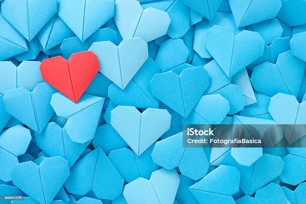 Red paper heart Lots of blue origami paper hearts with a red one over them Heart Shape Stock Photo