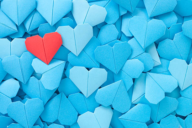 Red paper heart Lots of blue origami paper hearts with a red one over them romance concept stock pictures, royalty-free photos & images