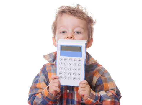 Little boy is demonstrating the result of calculations on a calculator.