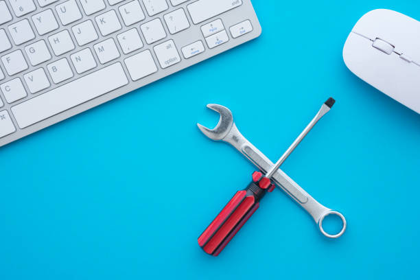 istock Flat lay of combination spanner or wrench, screwdriver, keyboard computer and mouse on blue background. 1605442089