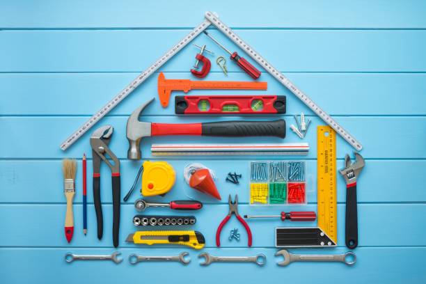 istock Flat lay of construction tools as house model on blue wooden background copy space. 1605453675