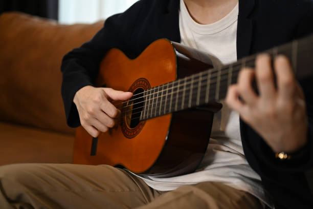 A man playing a guitar at home. Domestic life concept.