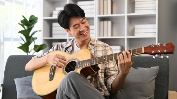 A man playing a guitar at home. Domestic life concept.