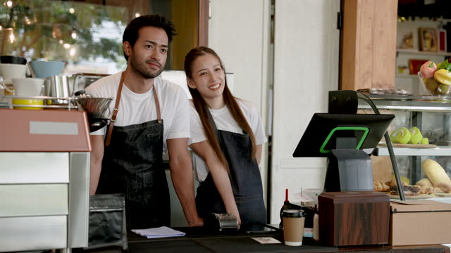 Portrait, Handsome young couple, beautiful Asian woman, Be owner cafe coffee shop here become full-fledged business, with passion for coffee cooking, this restaurant was created.