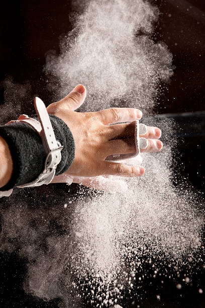 Chalk Powder Flies As Gymnast Preps for Bars stock photo