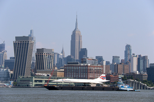 British Airways Concorde supersonic jet removed from Intrepid Sea, Air & Space Museum on August 9, 2023 and taking a barge ride to Brooklyn for a makeover and restoration. 
I photographed this historical event with famous Manhattan landmark buildings and iconic skyscrapers in New York city  from Weehawken / Hoboken, New Jersey