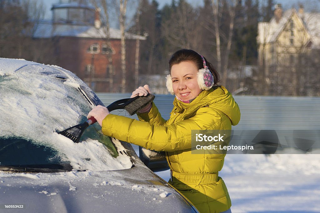 Dziewczyna Czyszczenie samochodu z śniegu - Zbiór zdjęć royalty-free (Biały)