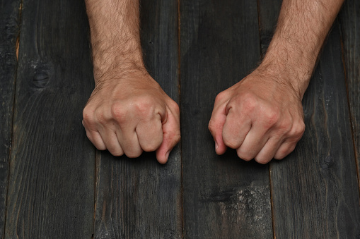 male fists on a wooden table