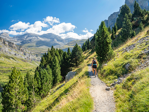 Woman doing sport and hiking in Ordesa National Park, in the Pyrenees, Huesca, Spain
