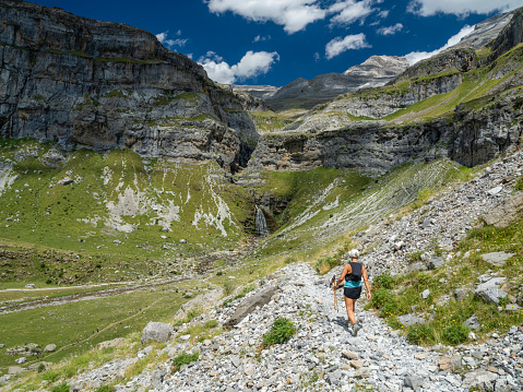 Woman doing sport and hiking in Ordesa National Park, in the Pyrenees, Huesca, Spain