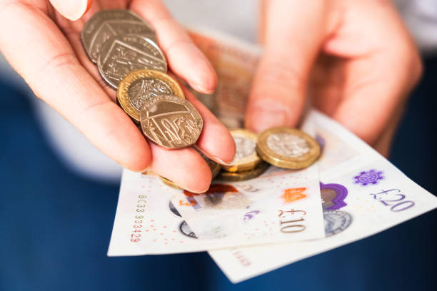 Showing UK coins and notes A selection of British coins with a £10 and £20 note. british currency stock pictures, royalty-free photos & images